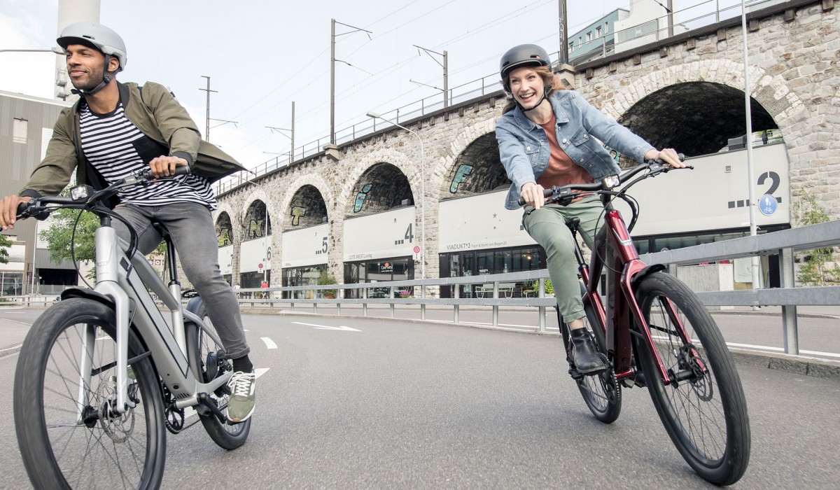 a man and a woman riding stromer bikes 