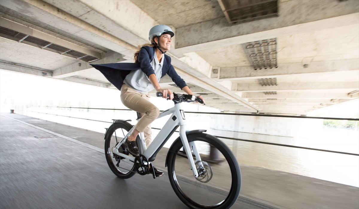 Frau auf E-Bike fährt durch die Stadt