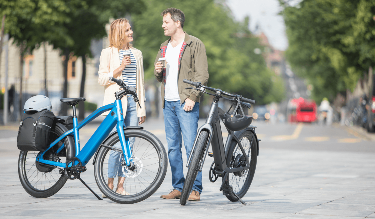 E-bike leasing private: Woman and man with coffee and their Stromer e-bikes.