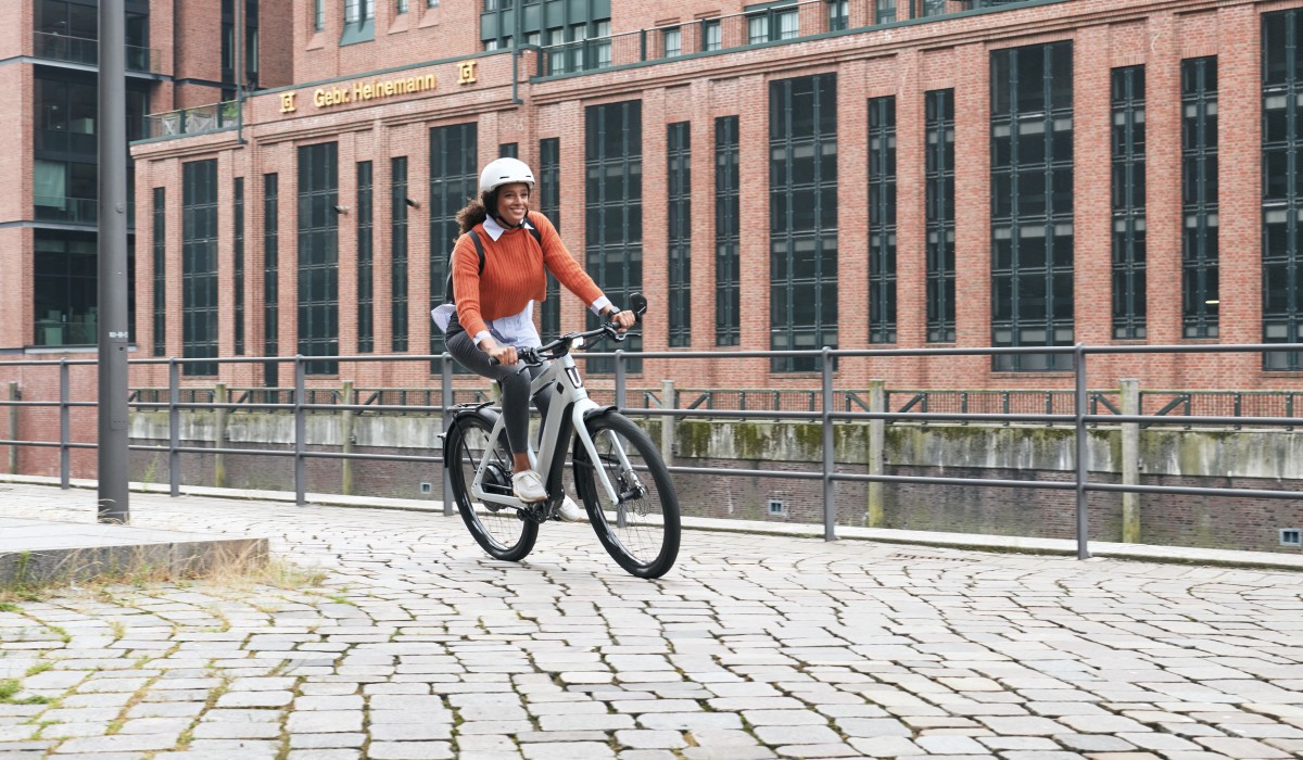Stromer E-Bikes finanzieren: Junge Frau fährt auf geleastem Stromer ST3 durch die Stadt.