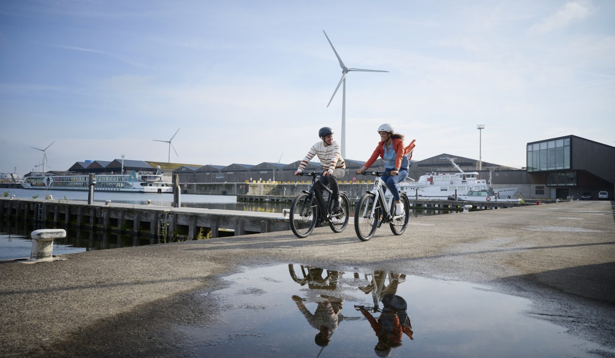 Dankzij e-bikeverzekering met een gerust hart op weg met uw Stromer speed-pedelec: man en vrouw rijden langs de haven.
