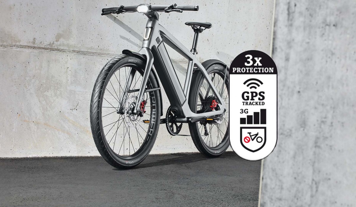 Triple protection antivol OMNI pour vélos électriques Stromer : un ST5 ABS devant un mur en béton avec l'icône Triple protection antivol. 