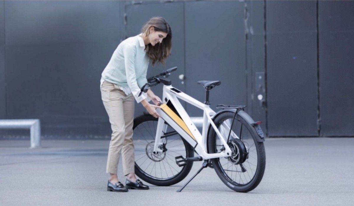 OMNI Keyless pour vélos électriques Stromer : une femme retire la batterie de son Stromer ST3 sans clé, par simple pression de bouton.