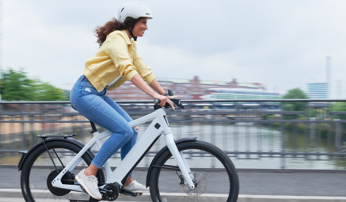 Woman rides a Stromer ST3 Pinion through the city – with a range of up to 150 km, can be optionally expanded to 180 km.