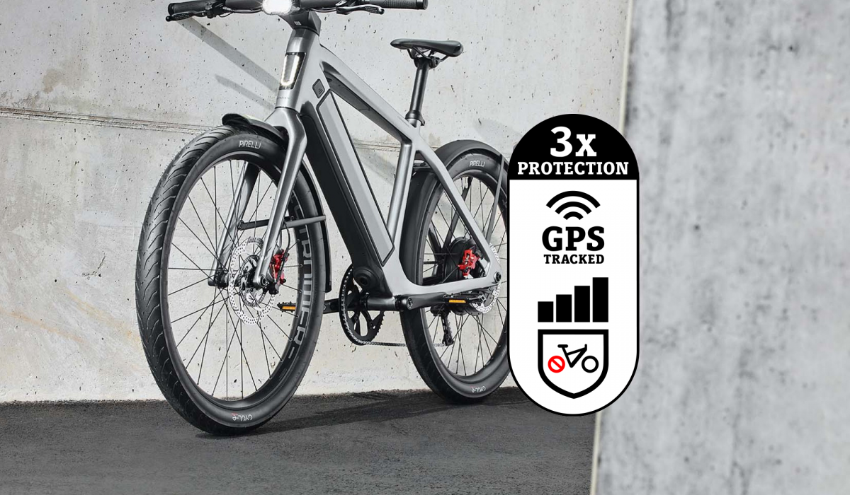 Triple protection antivol OMNI pour vélos électriques Stromer : un ST5 ABS devant un mur en béton avec l'icône Triple protection antivol. 
