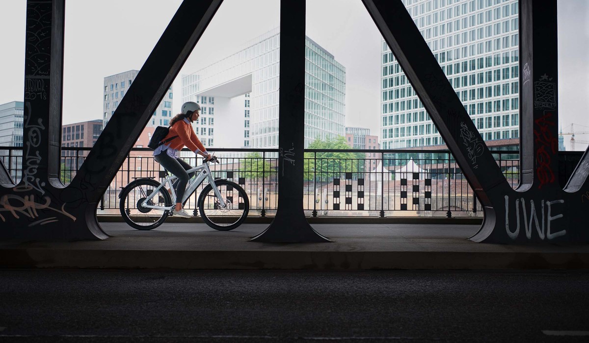 Woman rides a Stromer ST3 Pinion through the city – with a range of up to 150 km, can be optionally expanded to 180 km.